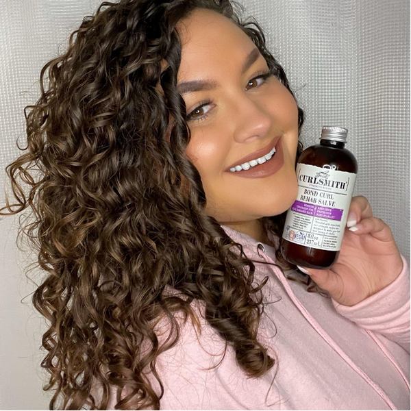 Woman holding Curlsmith Bond Curl Rehab Salve