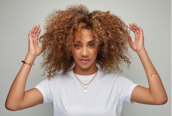 Woman with coily hair on a grey background