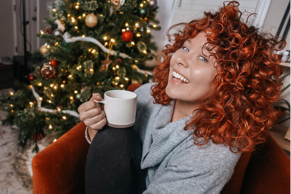 Woman with curly orange hair on a Christmas background