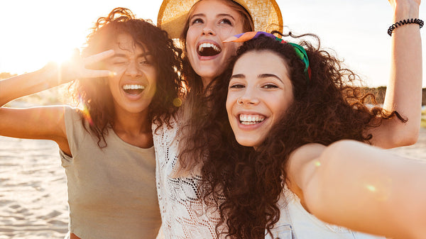 Three women with wavy hair on the beach