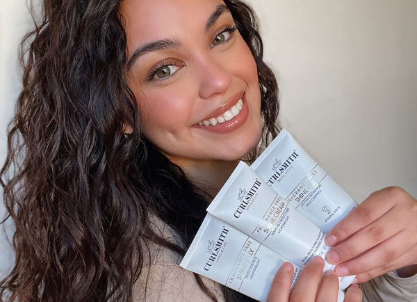 Woman holding three Curlsmith products