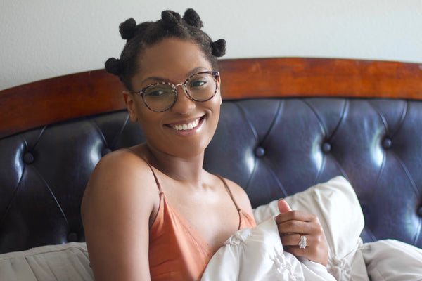 Smiling woman with Bantu knots and glasses