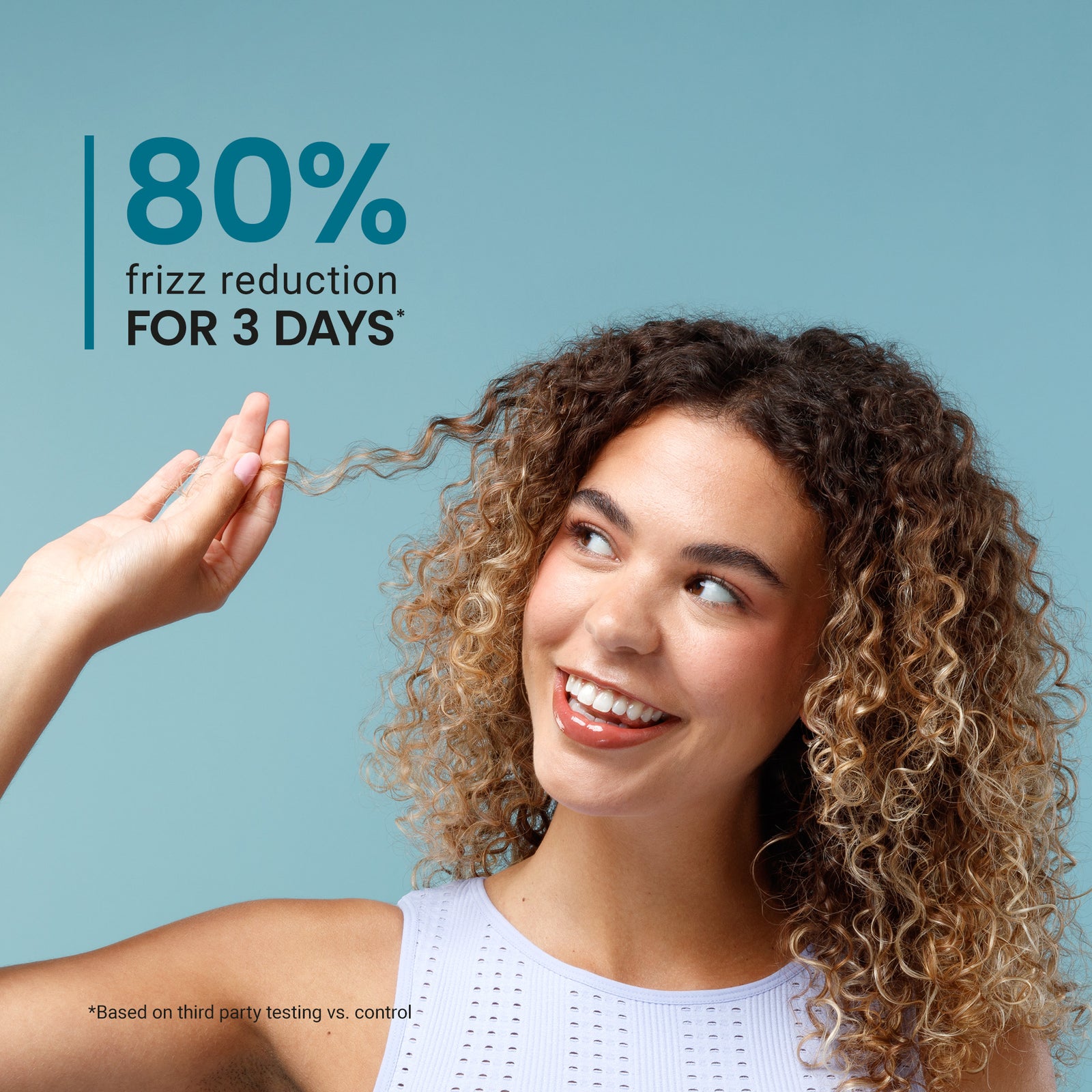 Woman with curly hair touching her hair, with text about frizz reduction on a blue background