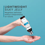 Hand holding a bottle of hair product with text on a blue background