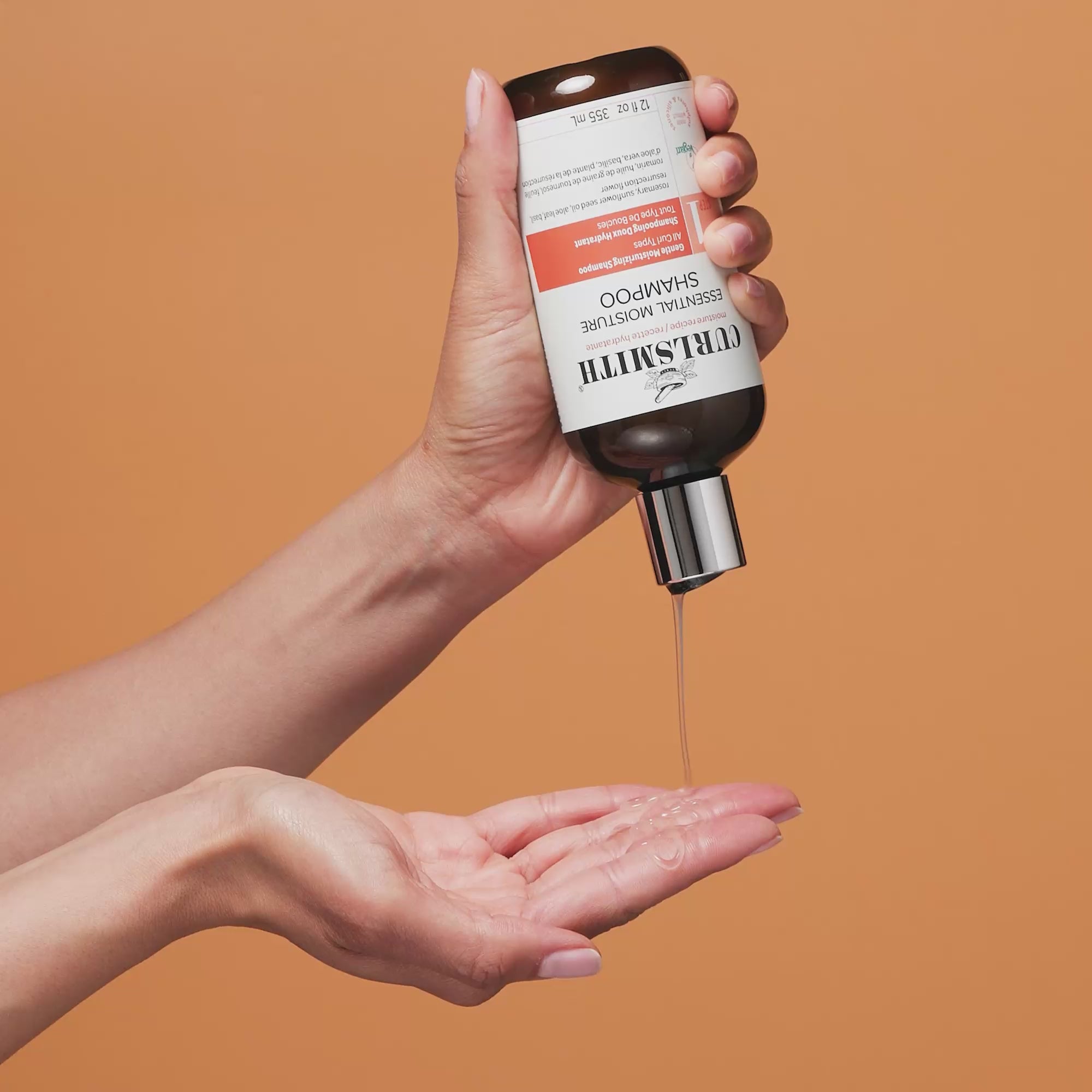 Hand applying Curlsmith Essential Moisture Shampoo